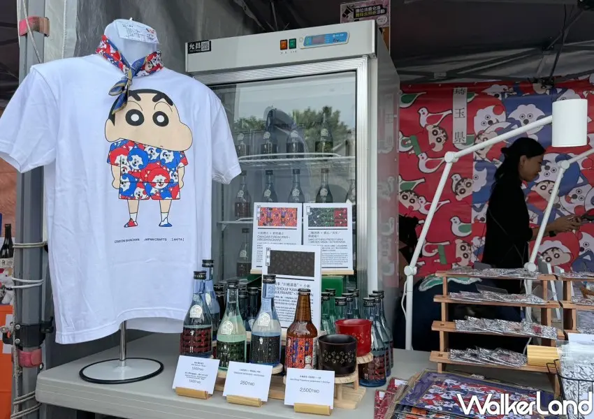 ▲2025日本秋田縣觀光物產展有和蠟筆小新聯名啤酒、服飾和周邊小物。(攝影:鄭雅之)