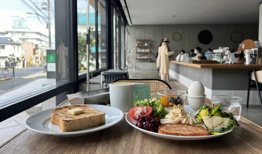 ▲踏入室內，原始水泥與木質構築的極簡美學令人瞬間平靜，點餐櫃檯前的是京都老路面電車鋪石，彷彿站著就能感應到那份跨越時空的歷史重量。