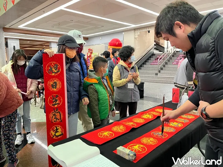 ▲港區藝術中心邀請名家書寫金墨春聯,吸引民眾排隊索取限量墨寶。圖/港區藝術中心提供;窩客島整理