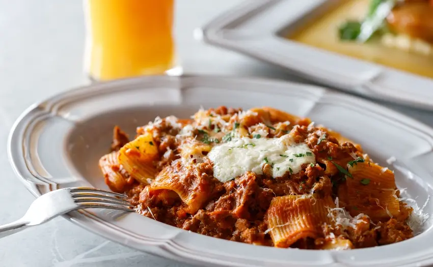 ▲私心推薦!「手工肉醬大水管麵」搭配每日新鮮現打的柳橙汁,酸甜果香中和濃郁肉醬,清爽解膩讓用餐更加 Chill。 圖/驢子餐廳提供;窩客島整理