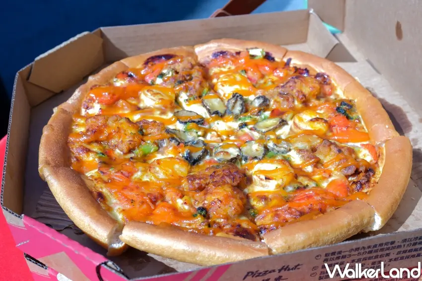 ▲必勝客春節主打金皇軟殼蟹鮑魚比薩，以高規格海鮮設定，成為不少家庭過年聚餐的方便選擇。