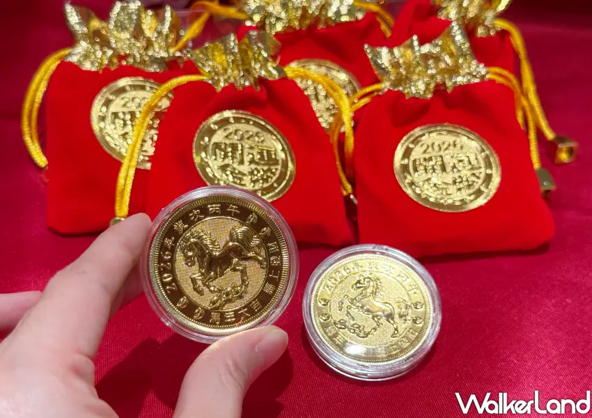 ▲兩枚純金打造的開運金幣搭配後方紅色的招財福袋，象徵新的一年財源廣進、福氣滿滿。(攝影：鄭雅之)