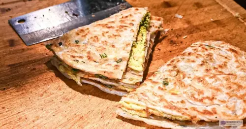 台北大稻埕永樂蔥油餅乾烙不油膩，二十六年排隊銅板美食甜甜圈必吃。