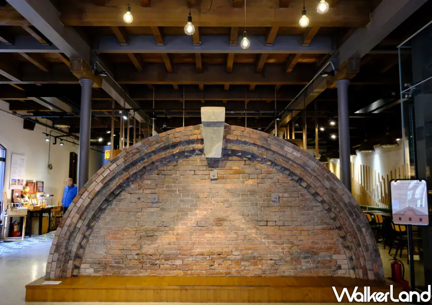 ▲室內展區保留了當時切割下來的半圓形舊山牆，讓參觀者能近距離感受日治時期倉庫的原始建築結構與風華。(攝影：鄭雅之)