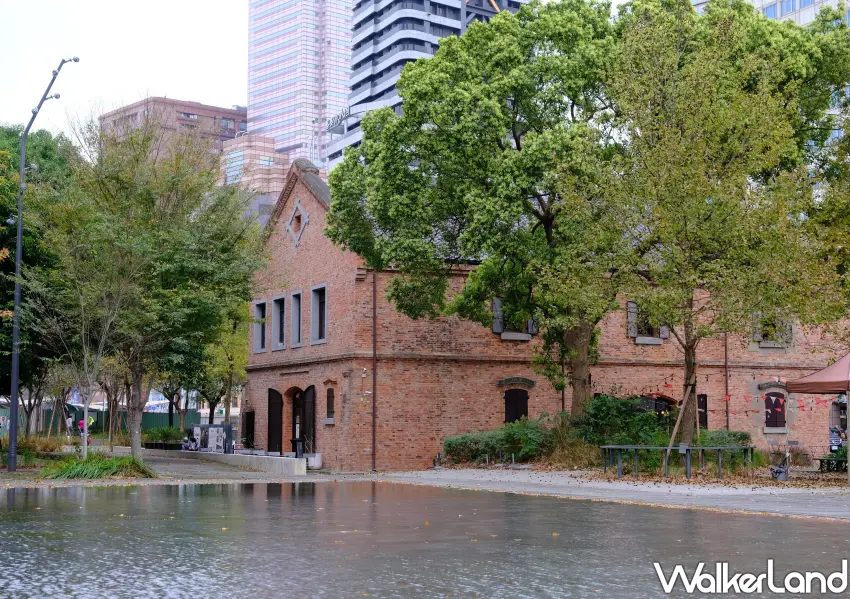 ▲磚紅色的臺北記憶倉庫與周圍綠意交織，後方現代大樓環繞，展現出新舊並蓄的城市生命力。(攝影：鄭雅之)