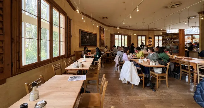 ▲貫穿店中央的木質長桌、敞亮開放的廚房都透露著悠閒感。