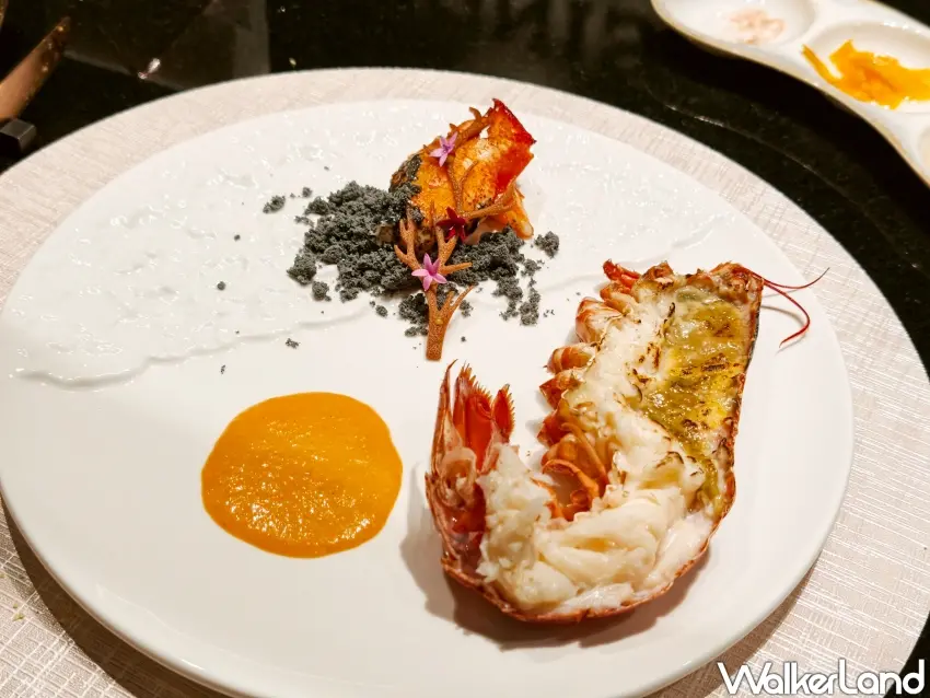 ▲「IGNIS伊尼斯鐵板燒」精緻套餐或晚餐套餐則會有嚴選龍蝦，以橘黃色蘭姆龍蝦醬與竹炭元素打造自然環境遭大火洗禮後的意象。（攝影：楊婷雅）