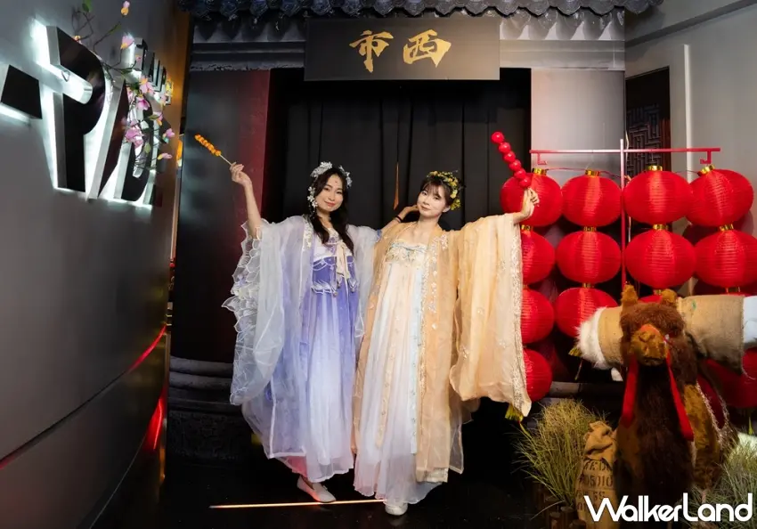 ▲穿上考究的霓裳羽衣，兩位女孩手拿著繽紛的糖葫蘆，在西市城門前展開一場跨越千年的時空漫遊，準備揭開大唐盛世的序幕。圖／i-Ride飛行劇院提供；窩客島編輯李維唐整理