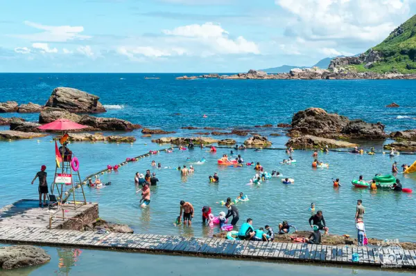▲新北貢寮一日遊景點推薦！夏天玩水聖地「龍洞灣海洋公園」利用自然礁石為護欄，打造天然海水泳池。(攝影：部落客 捲毛阿偉)