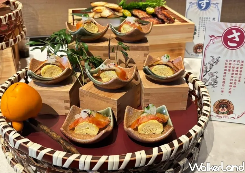 ▲以傳統五味為靈感設計精緻日式小品,精美的鰻魚玉子燒整齊排列在竹籃中,旁邊擺放著福丸角色的可愛告示牌。