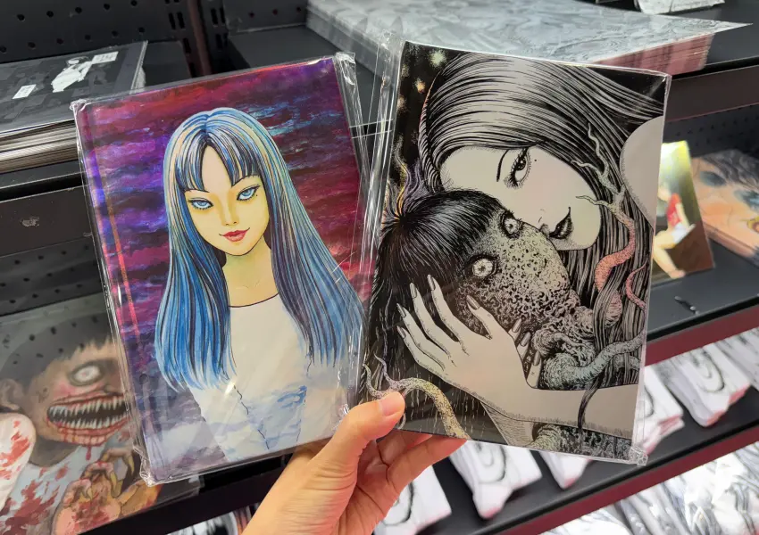 ▲台北松菸伊藤潤二展必買周邊!多款經典富江明信片、筆記本。(攝影:鄭亦庭)