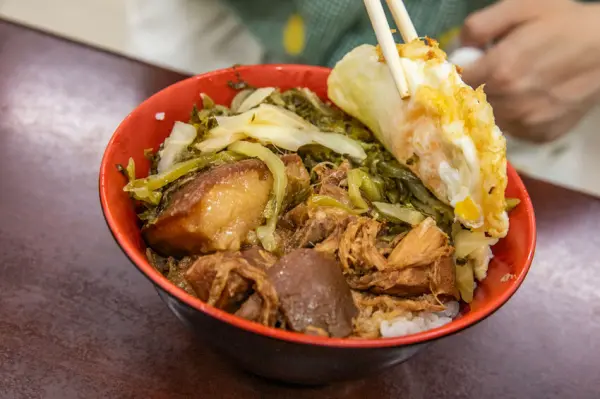 ▲高雄前鎮美食推薦必吃!華喜爌肉飯可依喜好選擇肥瘦部位,爌肉飯拌著半熟荷包蛋開吃。(攝影:部落客 大手牽小手。玩樂趣)