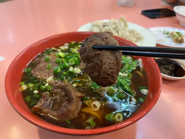 ▲新北八里美食推薦！梁師傅牛肉麵餃子館必吃牛肉麵牛肉軟嫩大塊、湯頭鮮美。(攝影：部落客 小臉)