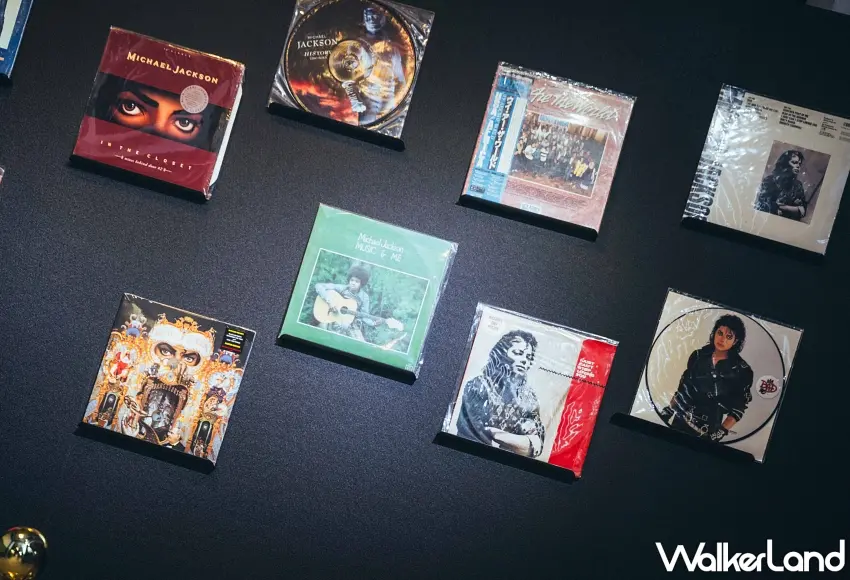 ▲黑色牆面擺設多款麥可傑克森經典黑膠唱片與周邊展示區,打造視覺感豐富的音樂展示空間。圖/KYUBI提供;窩客島編輯李維唐整理