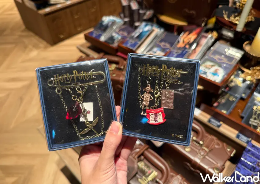 ▲哈利波特電影25週年紀念周邊!拆解式別針胸針有著各集電影元素吊飾。(攝影:鄭亦庭)