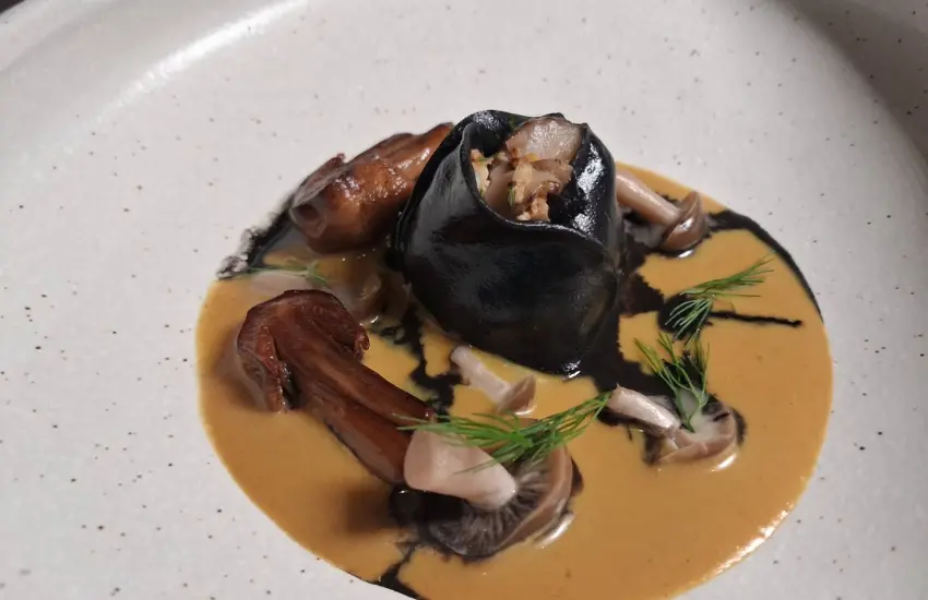 ▲重塑南法名港經典淡菜料理,以墨汁麵餃包覆黑淡菜,搭配慢速發酵香菇湯底。
