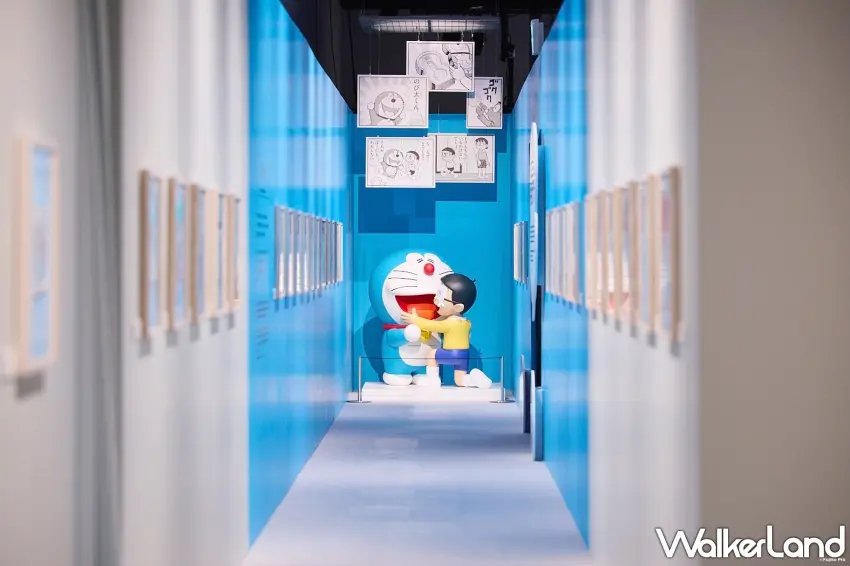 ▲走進藍白色展覽廊道,視線一路延伸到哆啦A夢與大雄相擁的經典畫面,兩側再搭配漫畫展示,像是一秒走進藤子不二雄筆下的世界。圖/主辦單位提供;窩客島整理