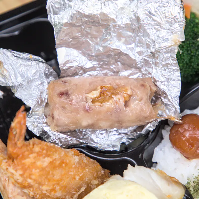 紅蕃茄小資便當中的松子捲特寫，這道店家獨家研發的特色料理，將香氣濃郁的松子與豬肉巧妙結合，口感豐富且獨特，是在其他地方吃不到的獨家美味。