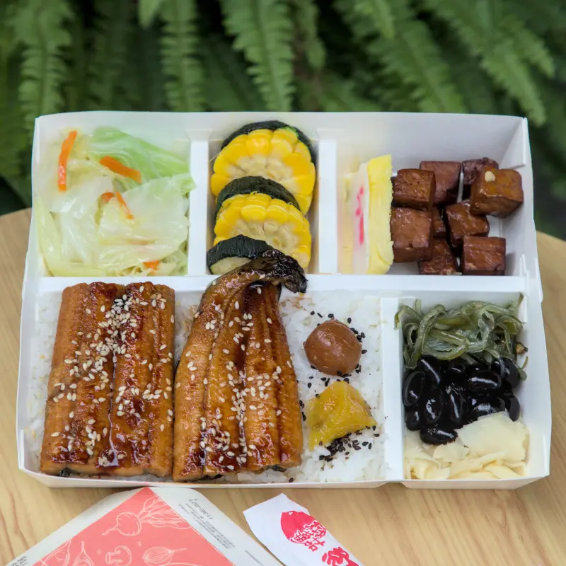 紅蕃茄330元鰻魚飯全景，便當裡有兩大片蒲燒鰻魚，搭配清炒高麗菜、蜜汁豆干、玉子燒等豐富配菜，色彩豐富，擺盤精緻，是視覺與味覺的雙重饗宴。