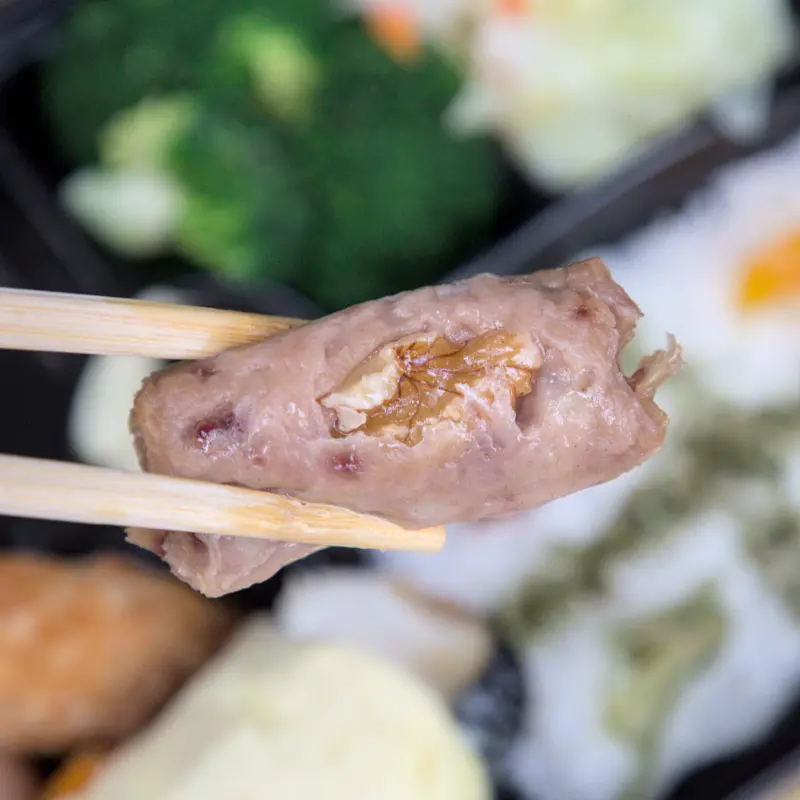 紅蕃茄小資便當中的松子捲剖面圖，清晰可見肉捲中鑲嵌的松子，證明用料實在，口感獨特，是便當中的一大亮點。