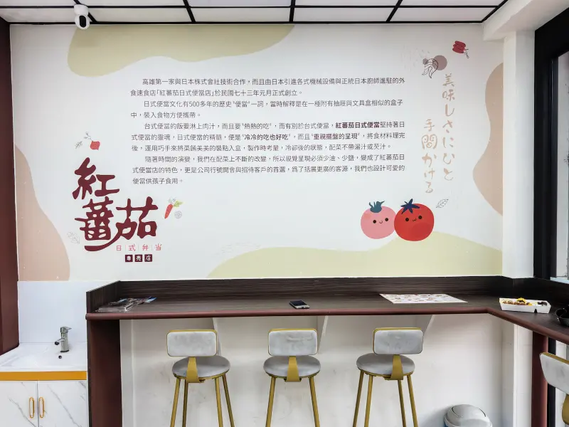 紅蕃茄日式便當店內牆面的大型彩繪壁畫，畫有可愛的紅蕃茄吉祥物與中、日文介紹，詳細闡述店家的創業理念與便當特色，將品牌精神與設計美學完美結合。