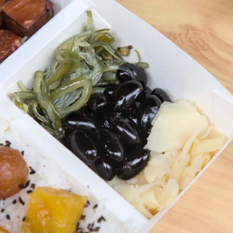 紅蕃茄鰻魚飯的涼拌小菜，涼拌黑豆、海帶芽與嫩薑，這些配菜不僅色彩搭配漂亮，也提供了清爽解膩的口感，讓便當風味更上一層樓。