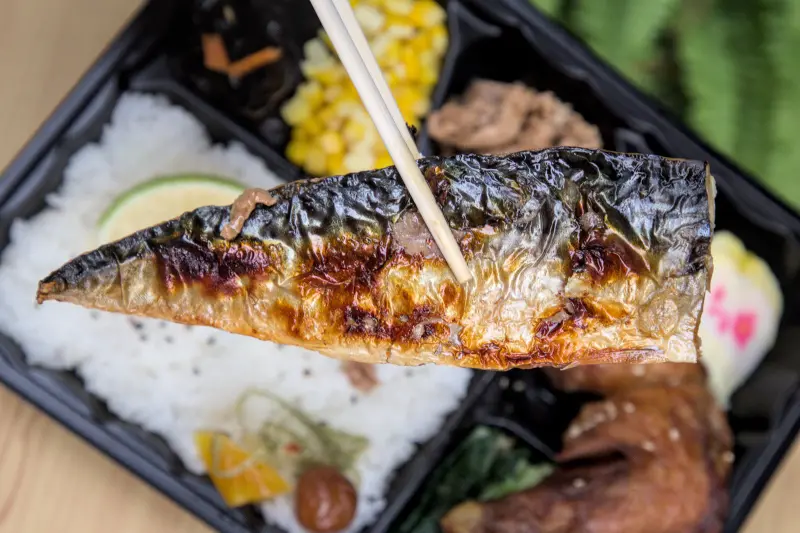 紅蕃茄250元三拼便當中的薄鹽鯖魚特寫，烤得金黃酥脆的魚皮與鮮嫩的魚肉，肉質扎實細緻，以薄鹽處理方式，顛覆傳統便當魚的重鹹印象，清爽無負擔。