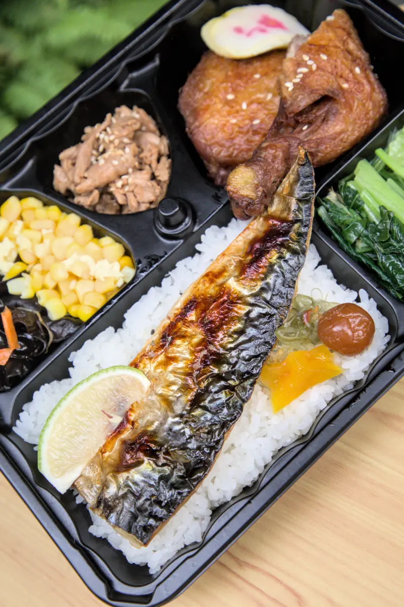 紅蕃茄250元三拼氣派組合便當的近照，主菜份量十足，擺盤精緻，配菜如甜玉米粒、涼拌木耳、爽脆高麗菜等，讓便當內容更加豐富。