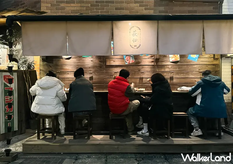 ▲桃園車站美食「萩佃」店面設計以日本屋台為概念，木製攤車搭配日式布簾與昏黃燈光 / WalkerLand窩客島 蕭芷琳 拍攝